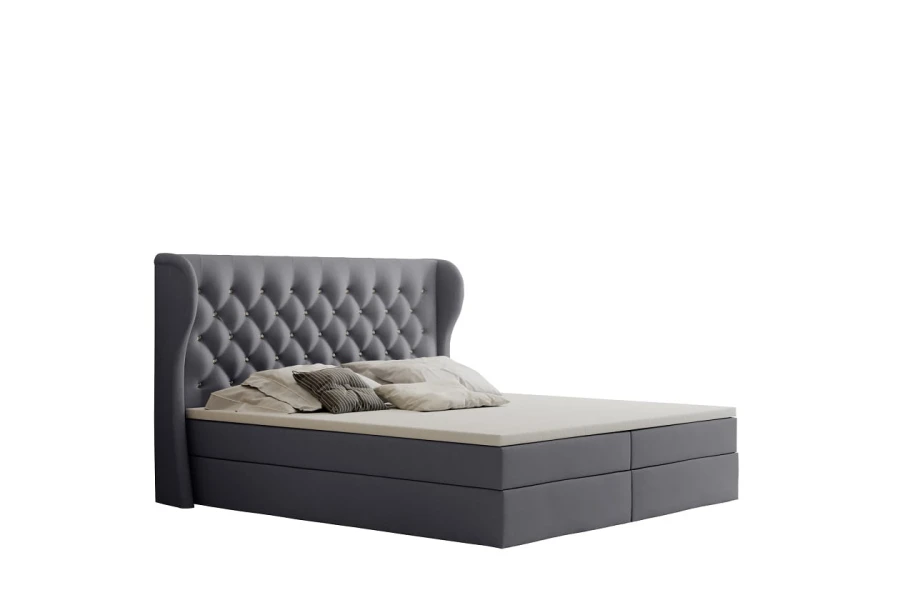 Dunkelgraues Boxspringbett mit elegantem Kopfteil und Knopfheftung auf weißem Hintergrund.