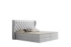 Weißes Boxspringbett mit hohem gepolstertem Kopfteil und praktischem Bettkasten.