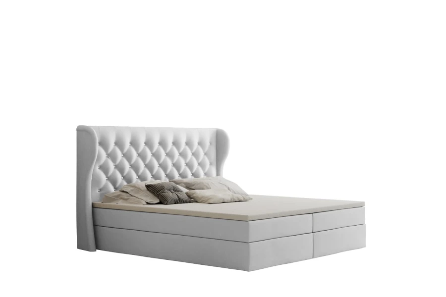Weißes Boxspringbett mit hohem gepolstertem Kopfteil und praktischem Bettkasten.