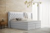 Modernes weißes Boxspringbett mit gestepptem Kopfteil im Schlafzimmer.