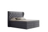 Graues Boxspringbett mit gestepptem Kopfteil vor weißem Hintergrund