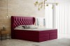 Magentafarbenes Polsterbett mit hohem Kopfteil und Chesterfield-Steppung in hellem Ambiente.