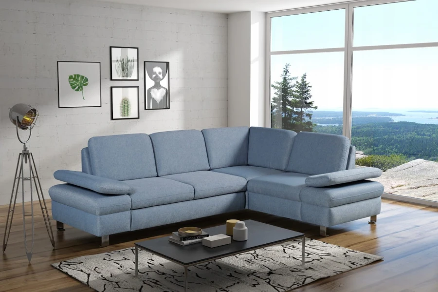 Modernes hellblaues Ecksofa in einem stilvollen Wohnzimmer mit großem Fenster.
