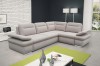 Modernes L-förmiges Ecksofa in Hellgrau mit neongrünen Akzenten in einem hellen Wohnzimmer.