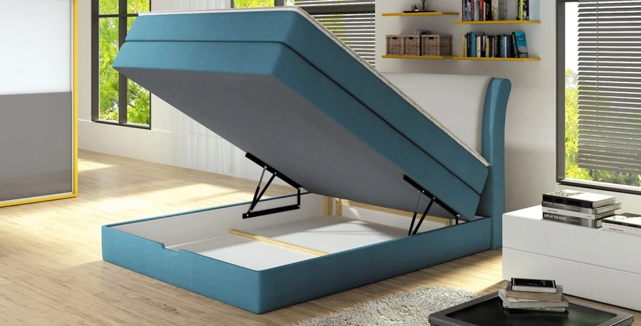 Funktionale Aufbewahrung: Blaues Boxspringbett mit geöffnetem Bettkasten.
