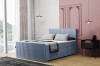 Hellblaues Polsterbett mit vertikaler Steppung an Kopf- und Fußteil in rosa Schlafzimmer.