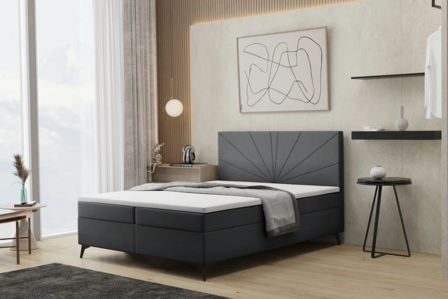 Elegantes dunkelgraues Boxspringbett mit fächerförmiger Steppung am Kopfteil.