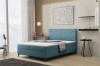 Modernes blaues Boxspringbett mit dekorativem Kopfteil im hellen Schlafzimmer.