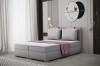 Modernes graues Polsterbett mit zwei Kissen und lila Decke in zeitlosem Schlafzimmer-Design.