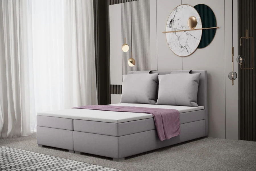 Modernes graues Polsterbett mit zwei Kissen und lila Decke in zeitlosem Schlafzimmer-Design.