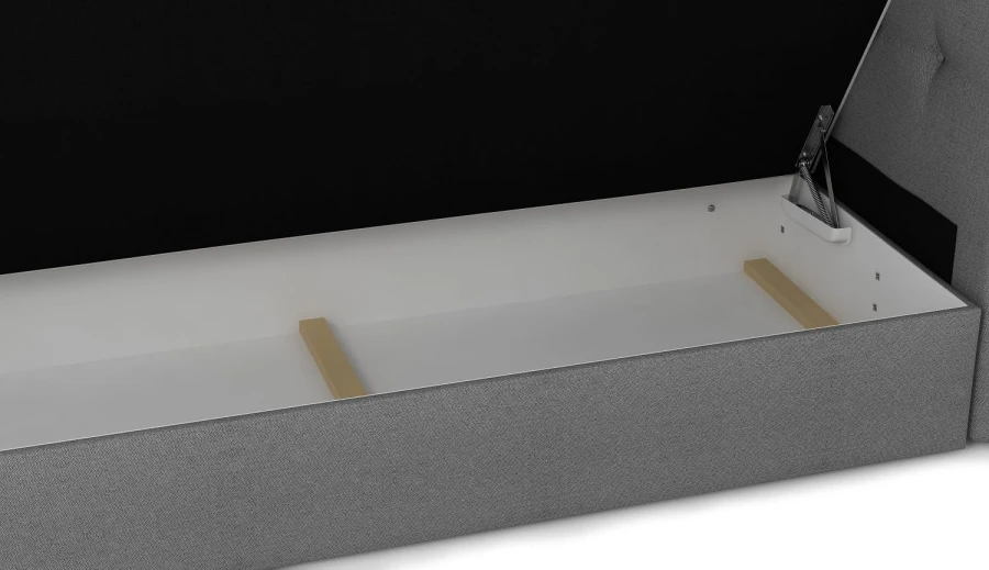 Geöffneter Bettkasten eines Boxspringbetts mit weißem Stauraum und grauem Stoffbezug.