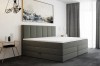Graues Boxspringbett mit hohem Kopfteil in modernem Schlafzimmer-Ambiente.