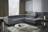 Dunkelgraue L-Form Couch für ein elegantes Wohnzimmer mit Kamin und Marmortisch.