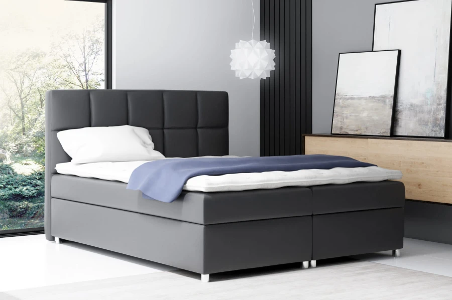 Elegantes dunkelgraues Boxspringbett mit dekorativem Kopfende.