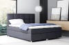 Modernes Boxspringbett in Dunkelgrau mit gepolstertem Kopfteil im Schlafzimmer.