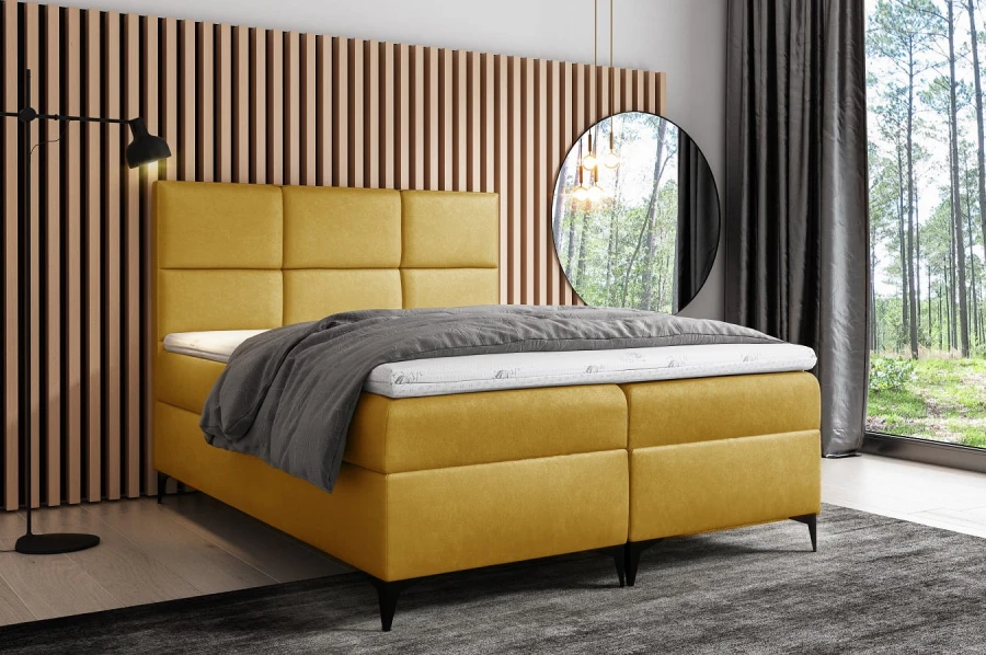 Modernes gelbes Boxspringbett mit gepolstertem Kopfteil in hellem Schlafzimmer.