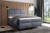 Graublaues Boxspringbett in minimalistischem Schlafzimmer mit Waldblick.
