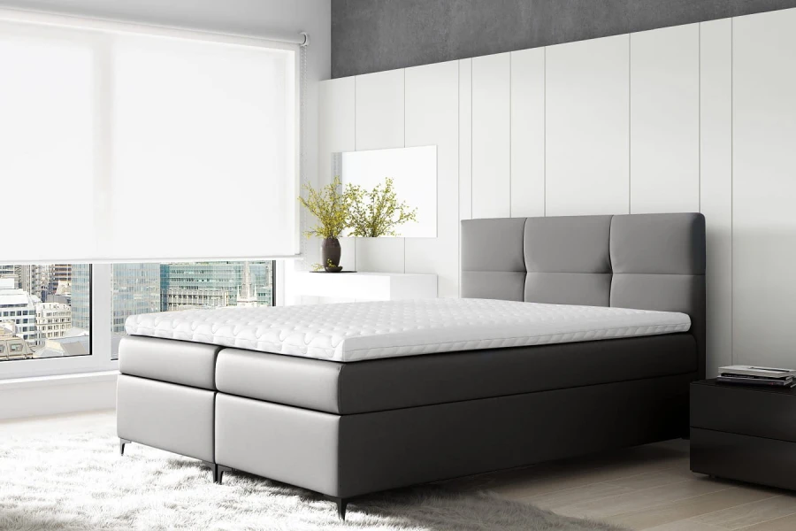 Modernes graues Boxspringbett in hellem Schlafzimmer mit Blick auf die Skyline.