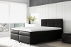 Zeitloses schwarzes Boxspringbett in minimalistischem Schlafzimmer mit Stadtblick.