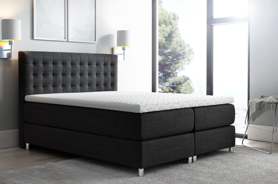 Dunkelgraues Boxspringbett mit hohem, gepolstertem Kopfteil für Schlafkomfort.