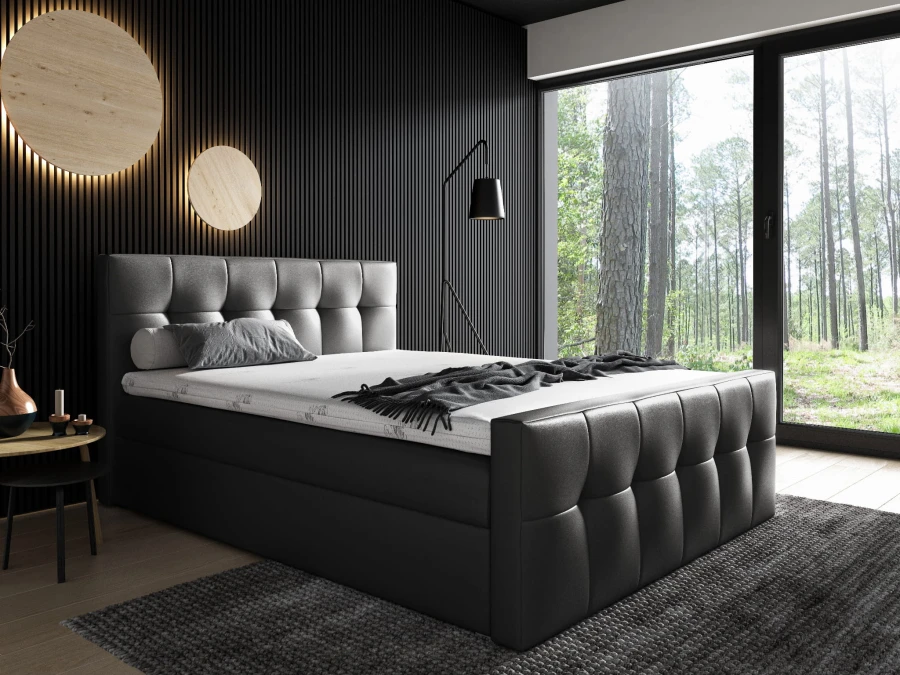 Modernes schwarzes Boxspringbett mit gestepptem Kopfteil und Fußteil im dunklen Schlafzimmer.
