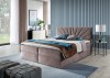 Rosa Boxspringbett mit strahlenförmig gestepptem Kopfteil in einem modern eingerichteten Raum.