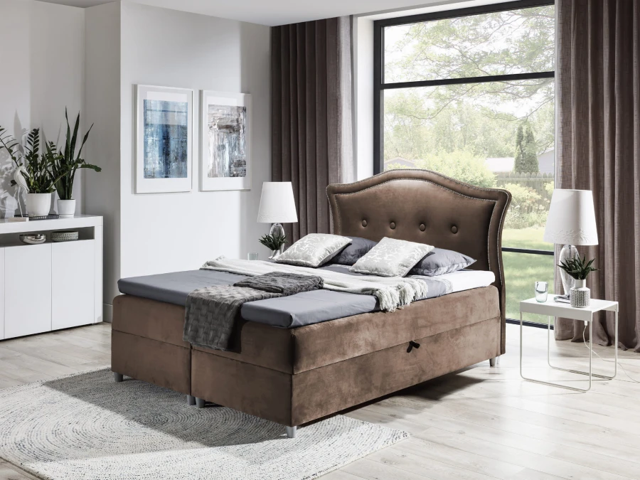Braunes Boxspringbett mit geschwungenem Kopfteil in zeitloser Optik