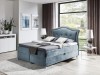Hellblaues Boxspringbett aus Samt mit dekorativem Kopfteil und Bettkasten.