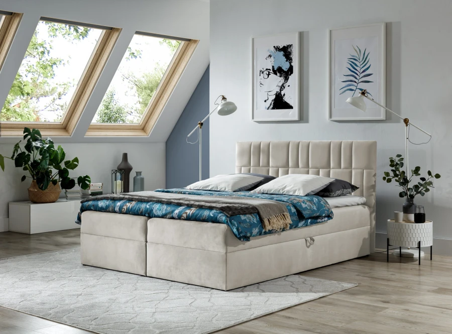 Beiges Boxspringbett mit gepolstertem Kopfteil in modernem Schlafzimmer mit Dachfenstern