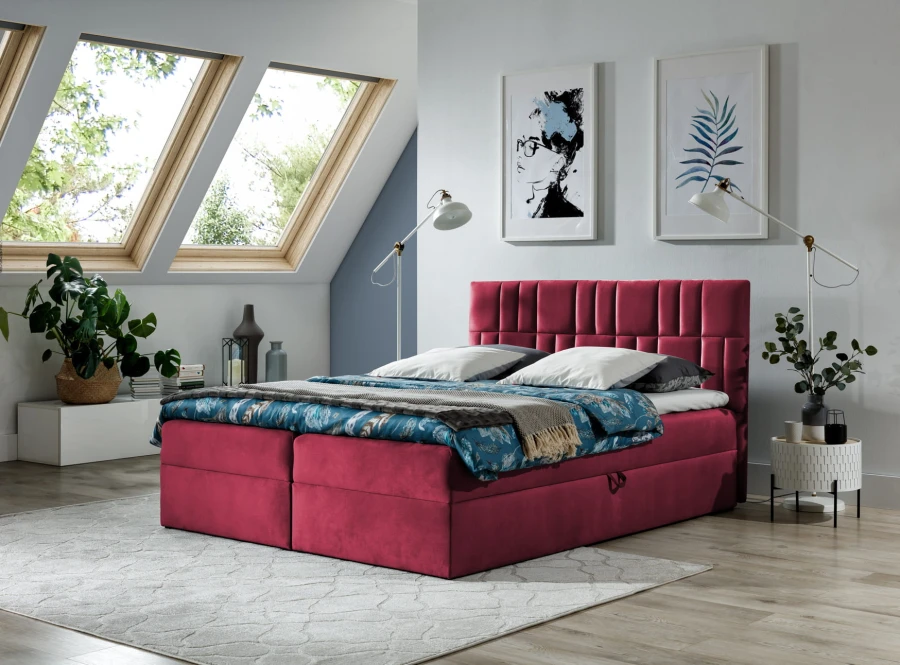 Weinrotes Boxspringbett mit Samtbezug in hellem Schlafzimmer mit Dachfenstern