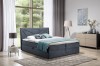 Modernes Boxspringbett in Blau mit dekorativem, geometrischem Kopfteil.