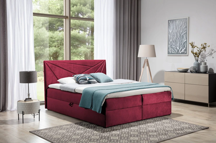 Rotes Boxspringbett mit geometrisch gestepptem Kopfteil im gemütlichen Schlafzimmer.