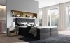 Anthrazitfarbenes Boxspringbett in modernem Schlafzimmer mit stilvoller Wandnische.
