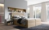 Beiges Boxspringbett in freundlichem Schlafzimmer mit modernem Design und viel Licht.
