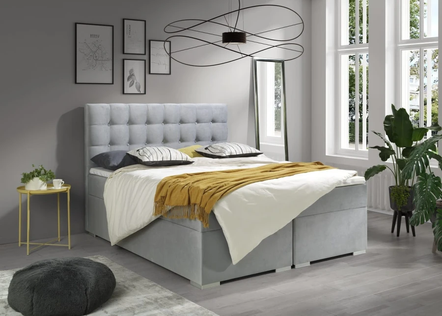 Hellgraues Boxspringbett mit gepolstertem Kopfteil in modernem Schlafzimmer.