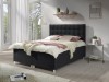 Schwarzes Boxspringbett mit gepolstertem Kopfteil und weißer Bettwäsche im hellen Schlafzimmer.