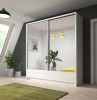 Weißer Schiebetürenschrank mit Spiegel in hellem Zimmer mit grünem Teppich und Pflanzen.