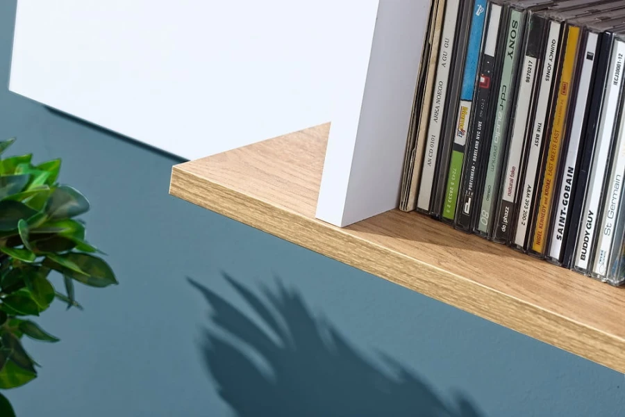 Stilvolles Wandregal in Eiche-Nachbildung mit CD-Sammlung und weißem Design-Element.