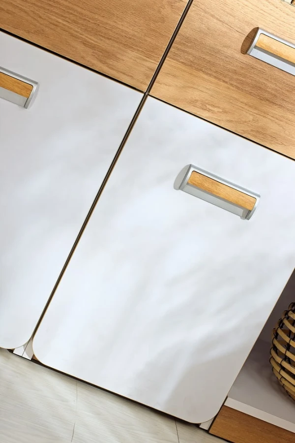 Weiße Kommodenfronten mit eleganten Holzgriffen und modernem zweifarbigem Look.
