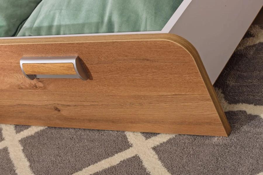 Detailaufnahme einer Schubladenfront in Holzoptik mit modernem Metallgriff.