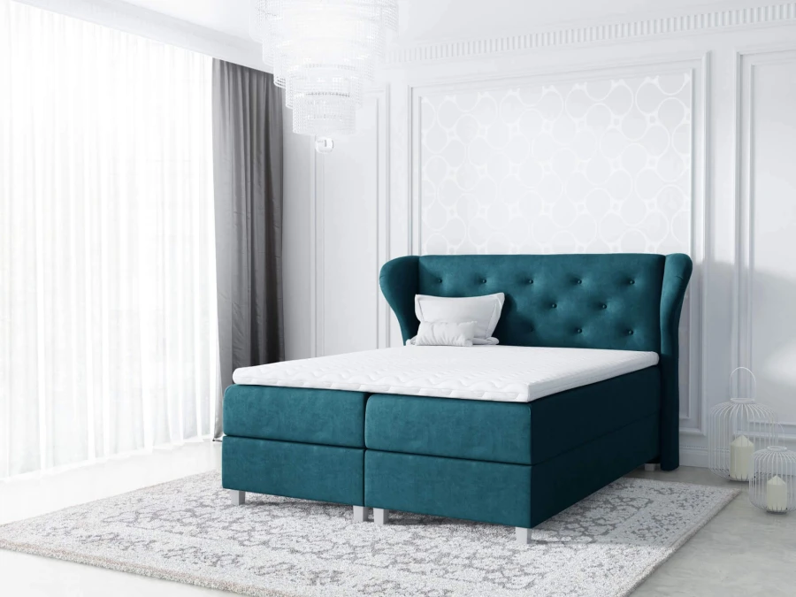 Boxspringbett in Petrol mit hohem, gestepptem Kopfteil für luxuriösen Schlafkomfort.