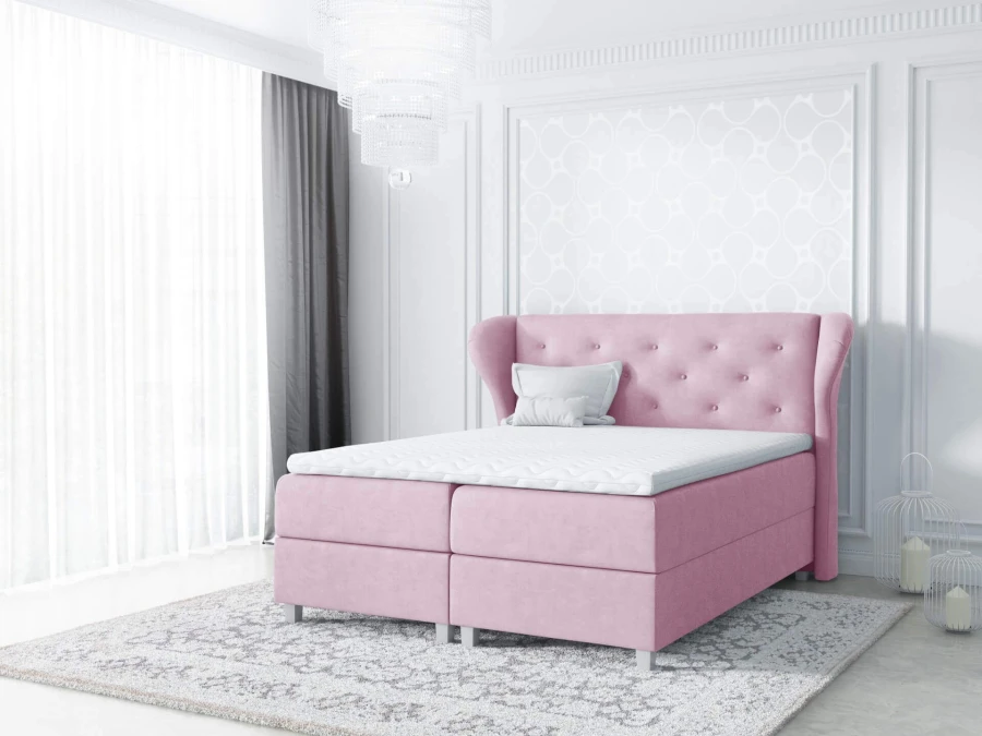 Rosa Boxspringbett mit Ohrensessel-Kopfteil in einem stilvoll eingerichteten Raum.