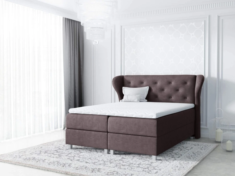 Braunes Boxspringbett mit Samtbezug und dekorativer Knopfheftung am Kopfteil.