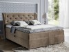Braunes Boxspringbett mit gestepptem Kopfteil und Bettkasten im Schlafzimmer