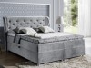 Graues Boxspringbett mit gepolstertem Kopfteil und Knopfheftung im modernen Design