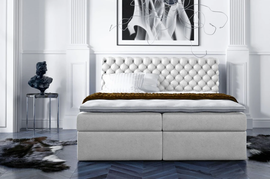 Hellgraues Boxspringbett mit edler Knopfheftung für luxuriösen Schlafkomfort.