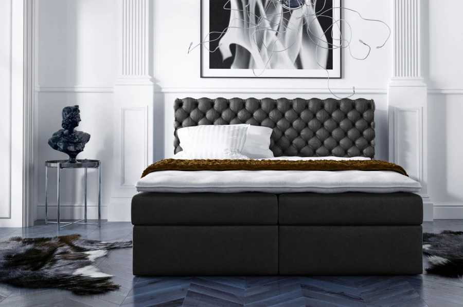 Dunkelgraues Boxspringbett mit gestepptem Polsterkopfteil in stilvollem Design.
