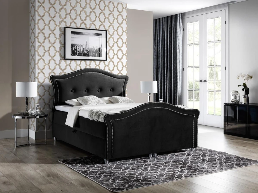 Schwarzes Samt-Polsterbett mit edler Knopfsteppung und elegant geschwungenem Rahmen.