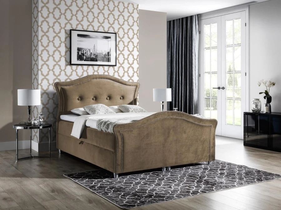 Beiges Polsterbett aus Samt mit Knopfheftung und geschwungenem Kopfteil im warmen Design.