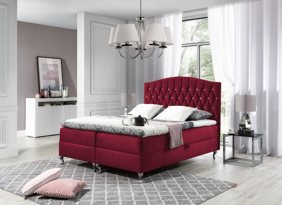 Rotes Boxspringbett mit Samtbezug und Knopfheftung am Kopfteil für elegantes Design.